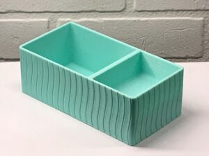 A Simple Stationairy Supplies organizer 3D printed in Cyan against a white background